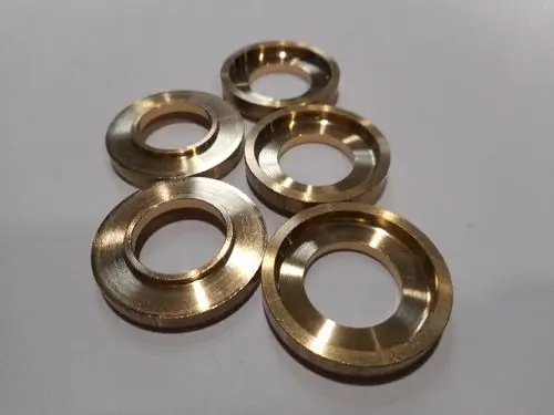 Set aus runden Metallzwischenstücken in Goldfarbe. Remeha Komponenten, die typischerweise in technischen Anwendungen oder Maschinen verwendet werden.